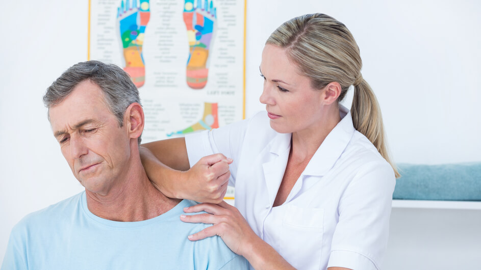 Foto:   Ärztin behandelt die Nackenschmerzen eines Patienten.