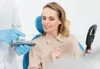 Arzt zeigt Patientin Zahnimplantate