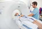 Arzt bereitet Patientin auf CT vor