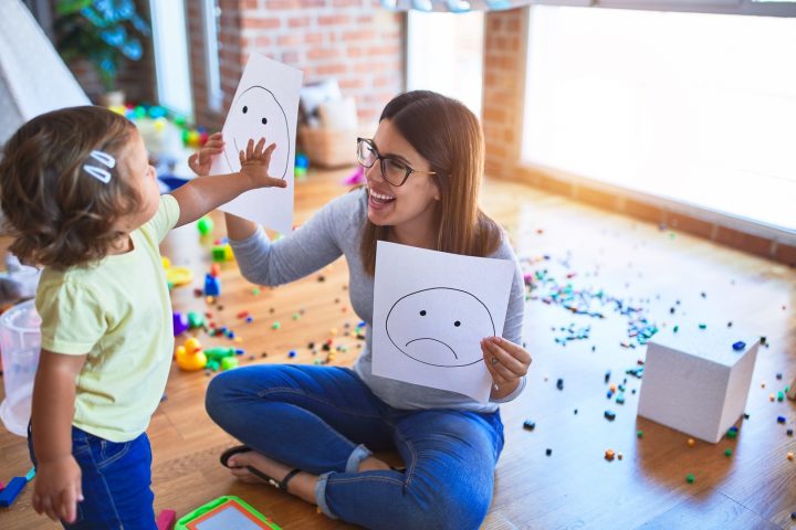Psychologin und Kleinkind bei der Therapie mit Emoji-Emotionen im Kindergarten