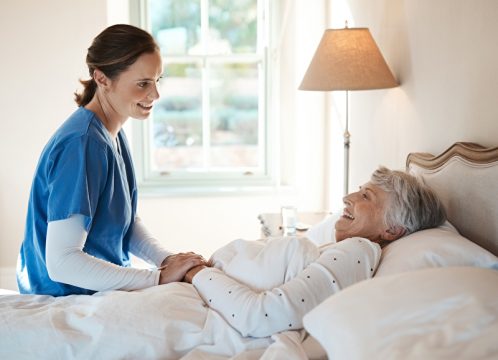Krankenschwester mit bettlägeriger Pflegepatientin