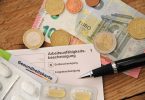 Krankenschein mit Tabletten und Stift