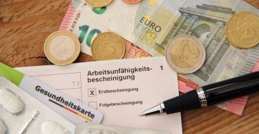 Krankenschein mit Tabletten und Stift
