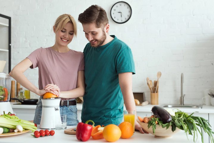 Junges Paar bereitet vitaminreiche Lebensmittel zu.