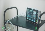Monitor zur Überwachung von Puls und Sauerstoffsättigung auf einem Rollwagen im Krankenzimmer