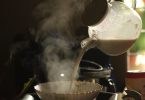 Dampfende Milch wird aus einer Kanne in eine Schale gegossen