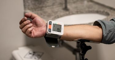 Arm mit einem Blutdruckmessgerät am Handgelenk