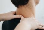 Hände massieren Nacken und Schulter eines Mannes