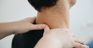 Hände massieren Nacken und Schulter eines Mannes