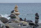 Aufgeschichtete Steintürme auf Felsen an der Meeresküste