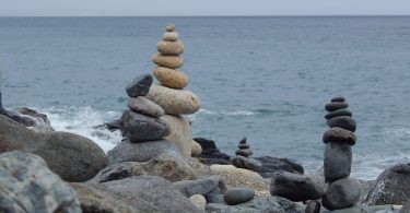 Aufgeschichtete Steintürme auf Felsen an der Meeresküste