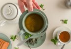 Teekannen und Tassen mit Kräutertee, Minze und Gebäck, von oben gesehen