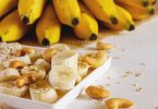 Bananenscheiben, Cashewkerne und Haferflocken, dahinter Bananen